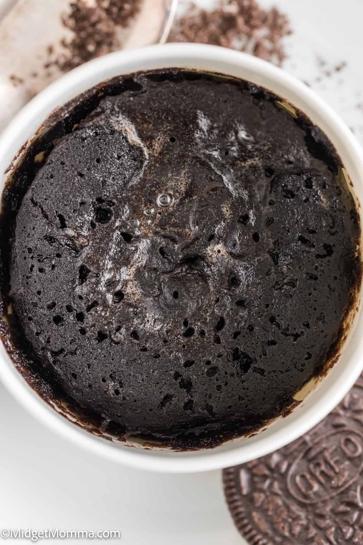 Close up photo of Oreo cookie mug cake in a white mug