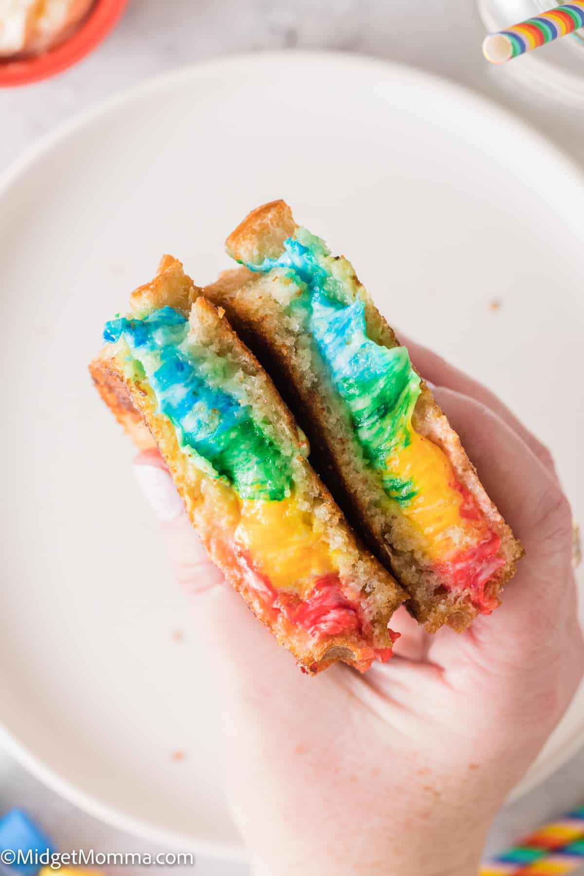 hand holding a Rainbow Grilled Cheese Sandwich