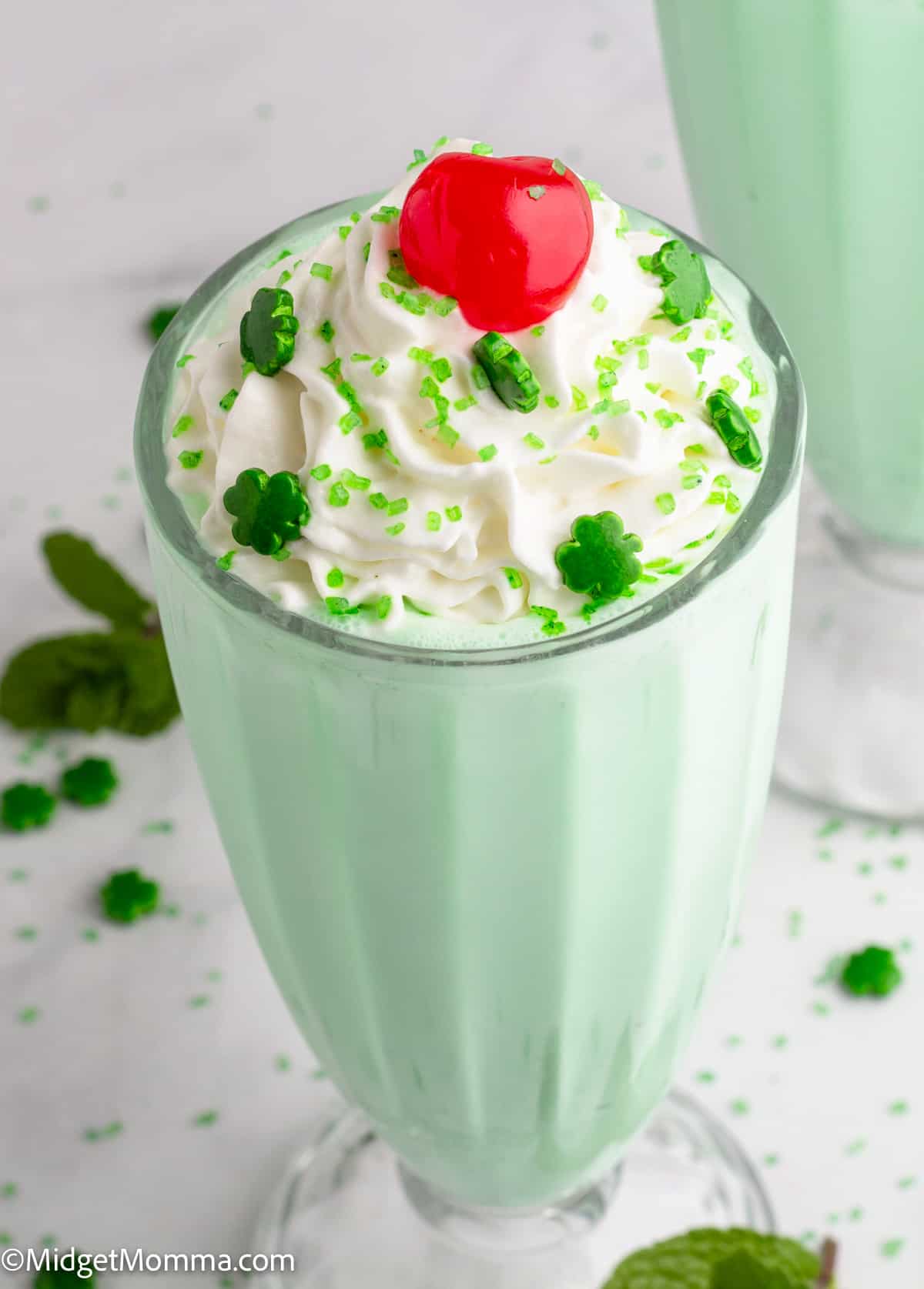 St patrick's day milkshake with whipped cream and a cherry.