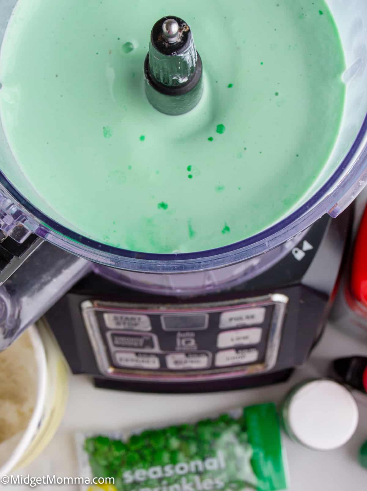 A green milkshake in a blender.