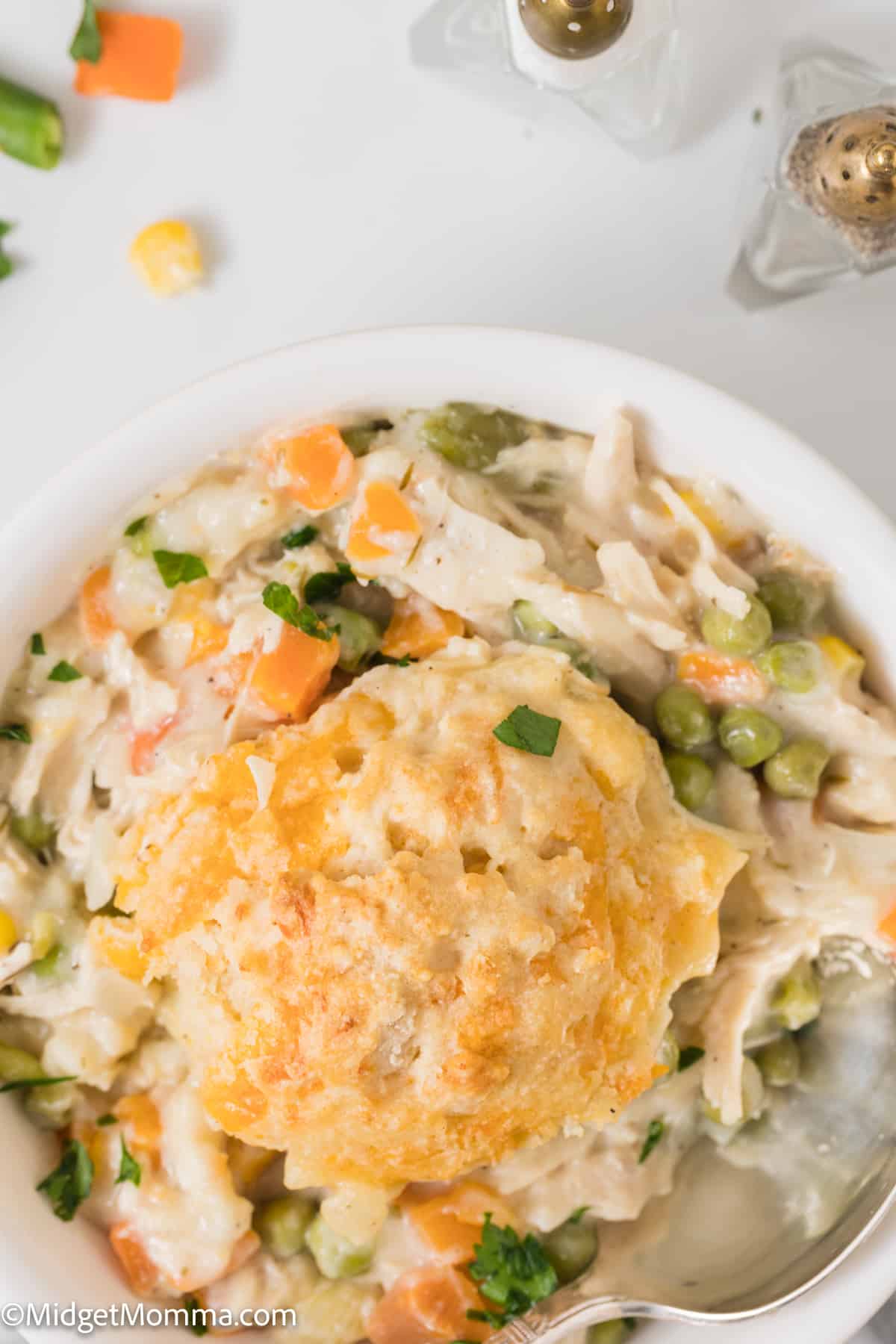Easy Chicken Pot Pie Casserole with Cheddar Drop Biscuit Topping in a bowl being served