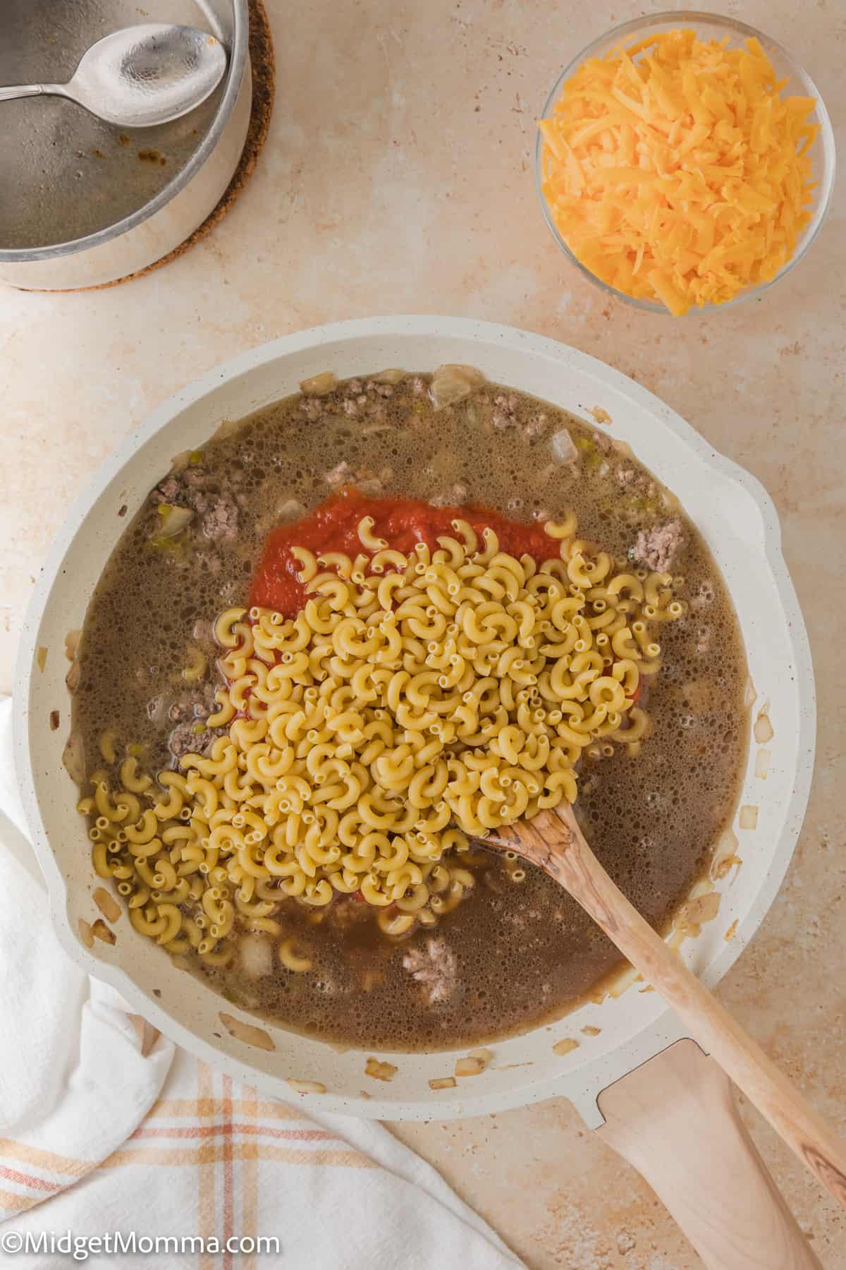 noodles being added to skillet making cheeseburger pasta hamburger helper recipe