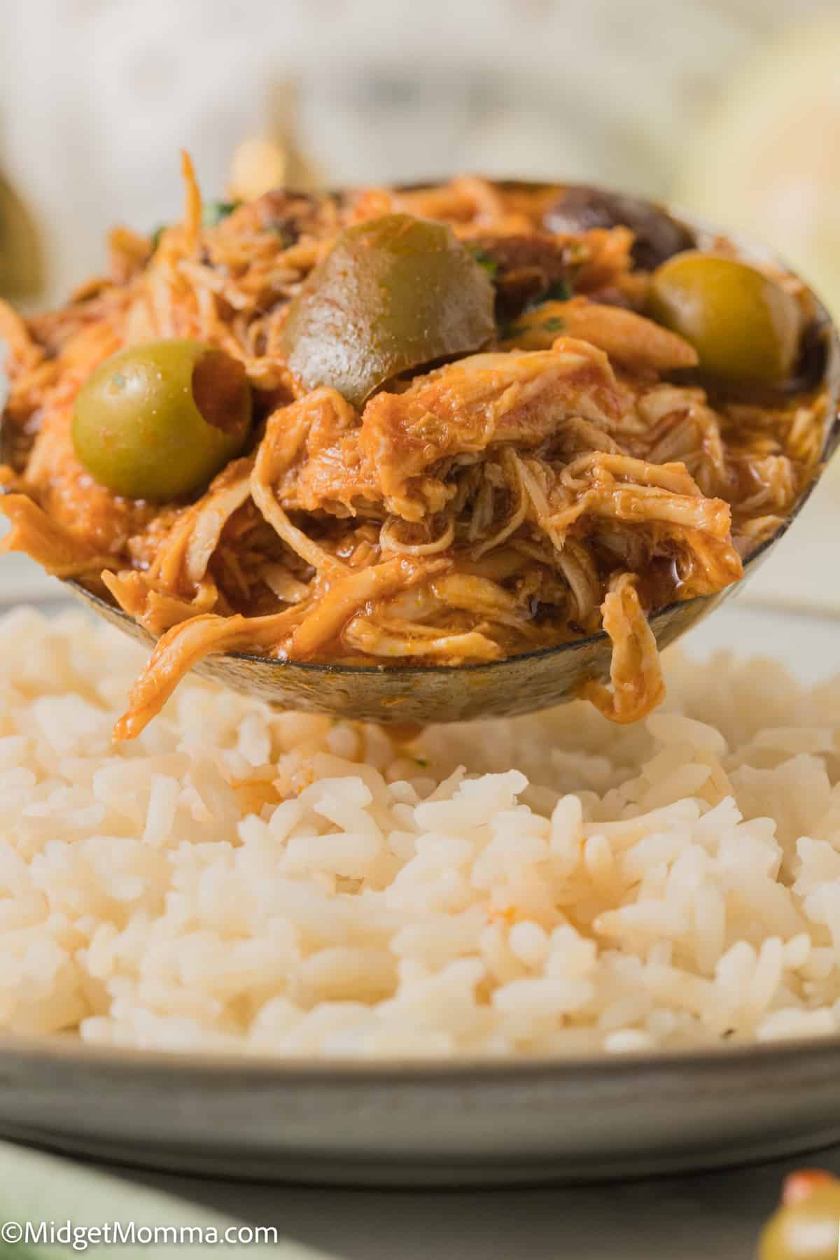 Slow Cooker Cuban Style Chicken Fricassee being spooned over rice