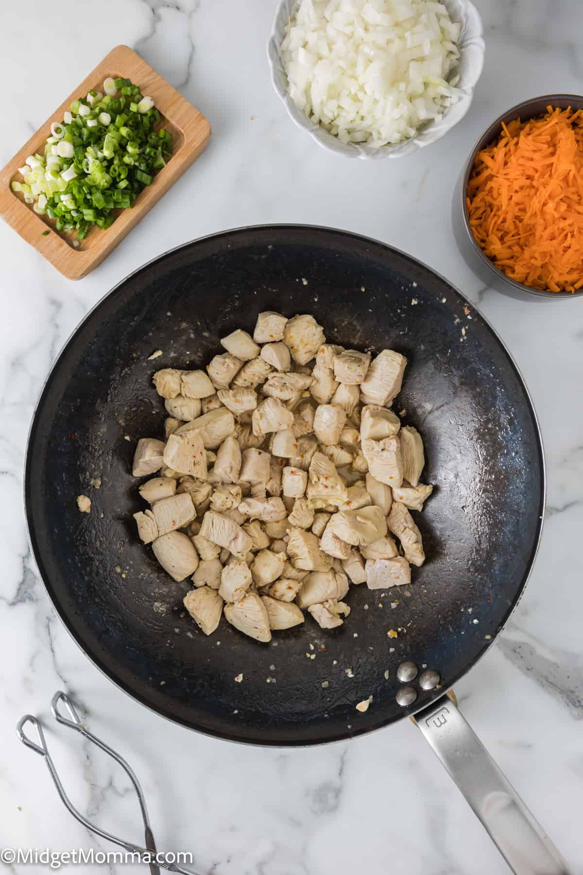 chicken cooking in a wok pan