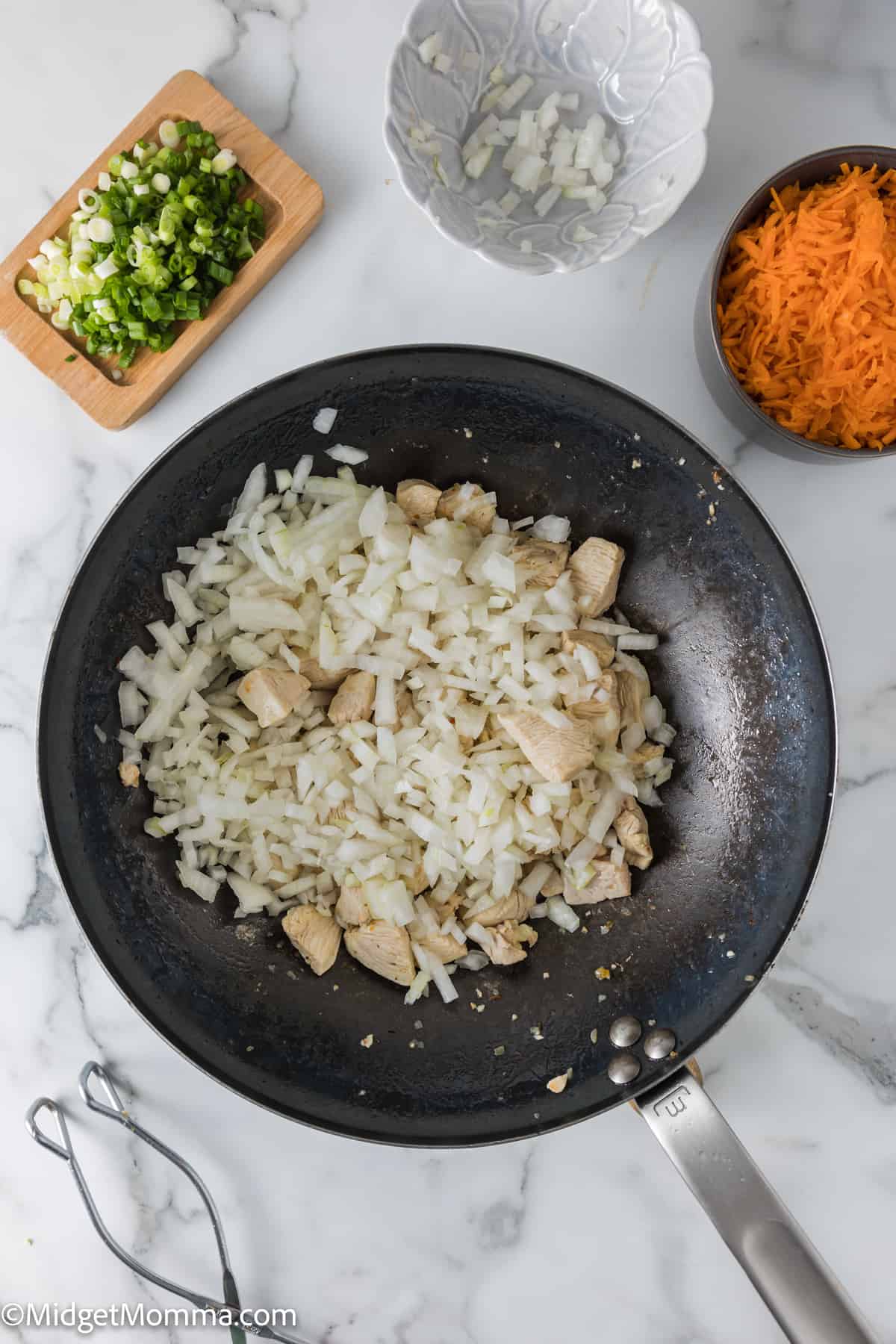 chicken and onions in a wok pan