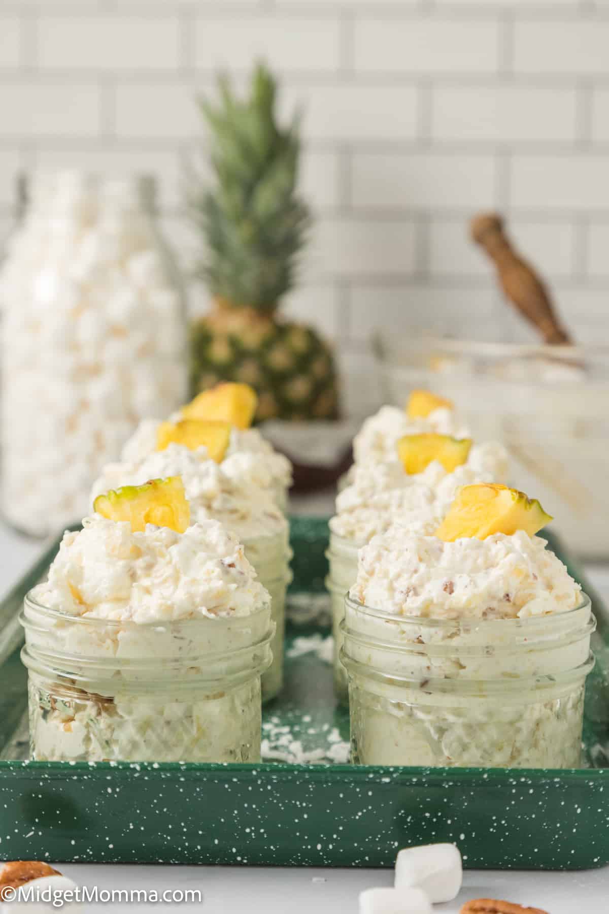 tray of individual mason jars with Then you need to make this easy pineapple fluff recipe and share it with your friends and family. This pineapple fluff recipe in them topped with a piece of fresh pineapple