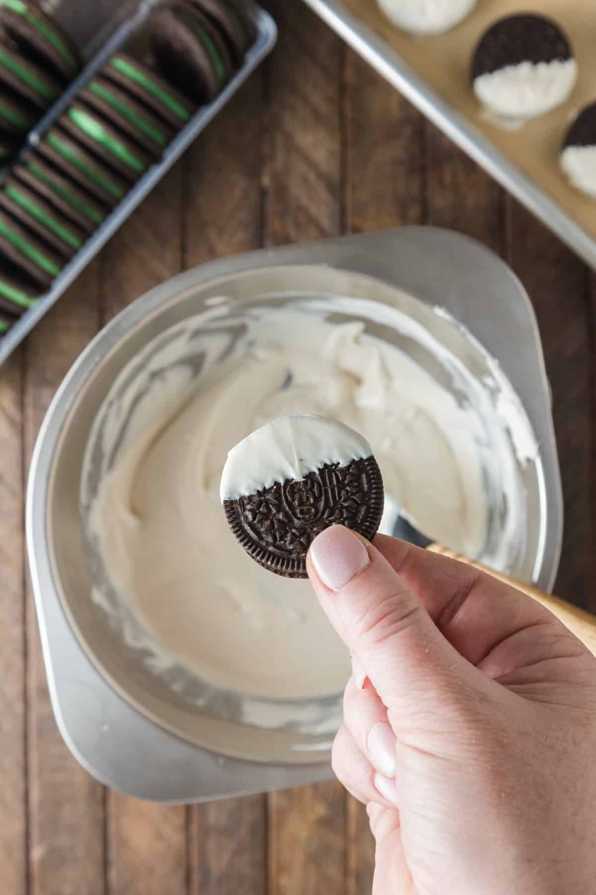 Oreo cookie being dipped into melted chocolate