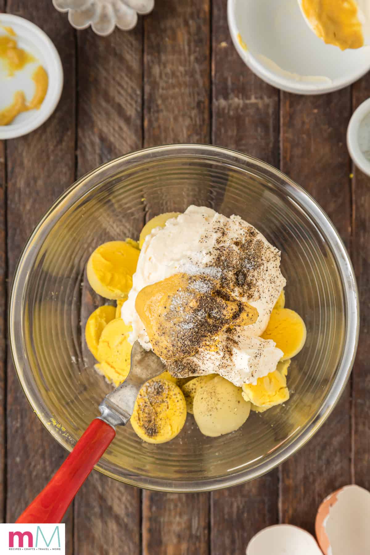 bowl with cooked egg yolks, mayo, mustard, salt, and pepper