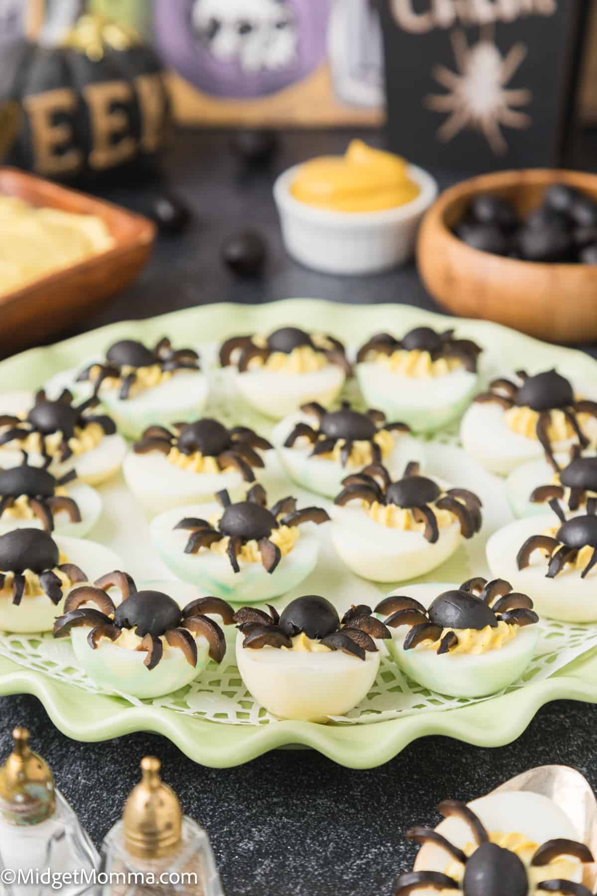 platter of deviled eggs with olive spiders on top
