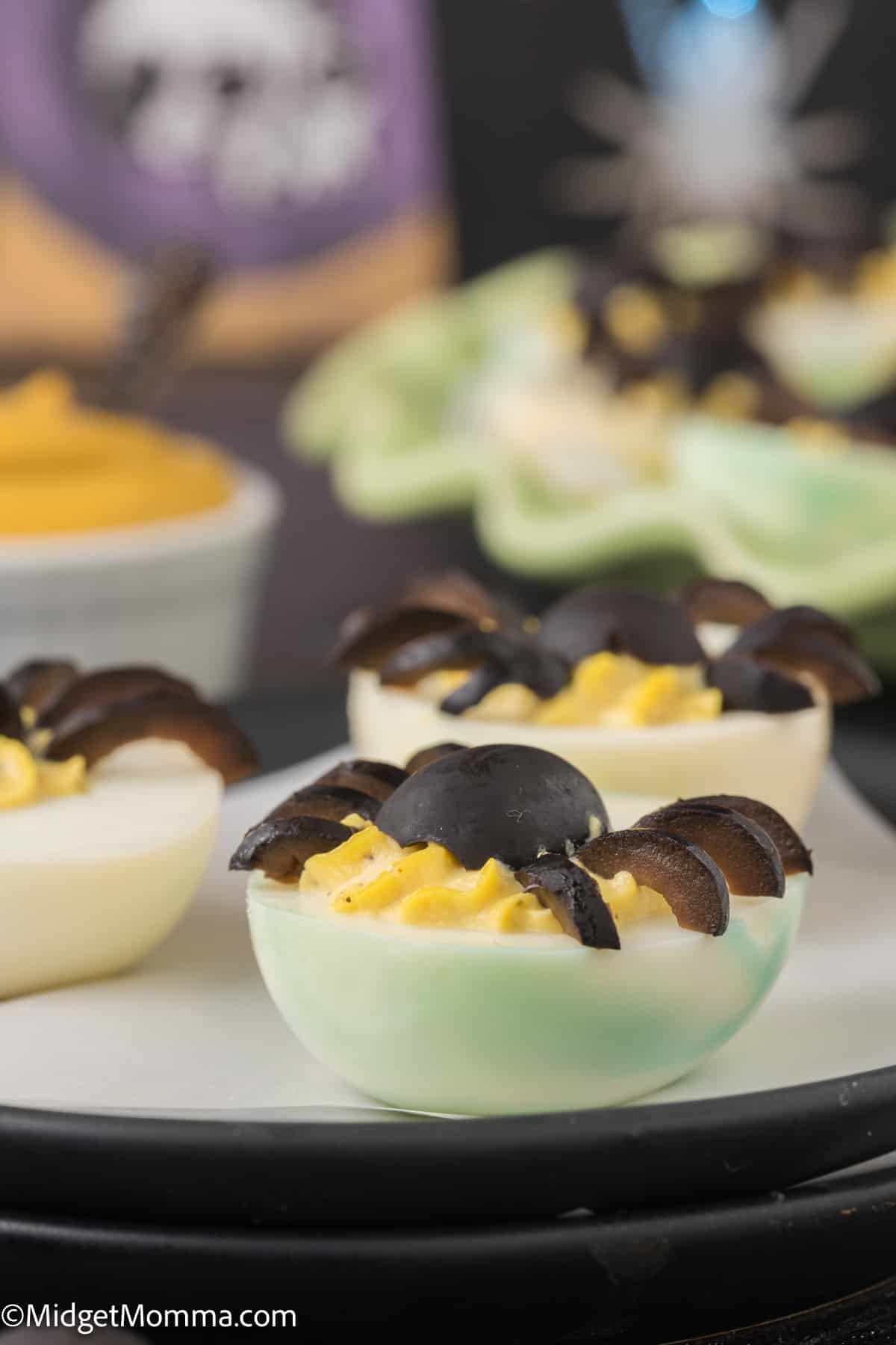 side view of deviled egg with an olive spider