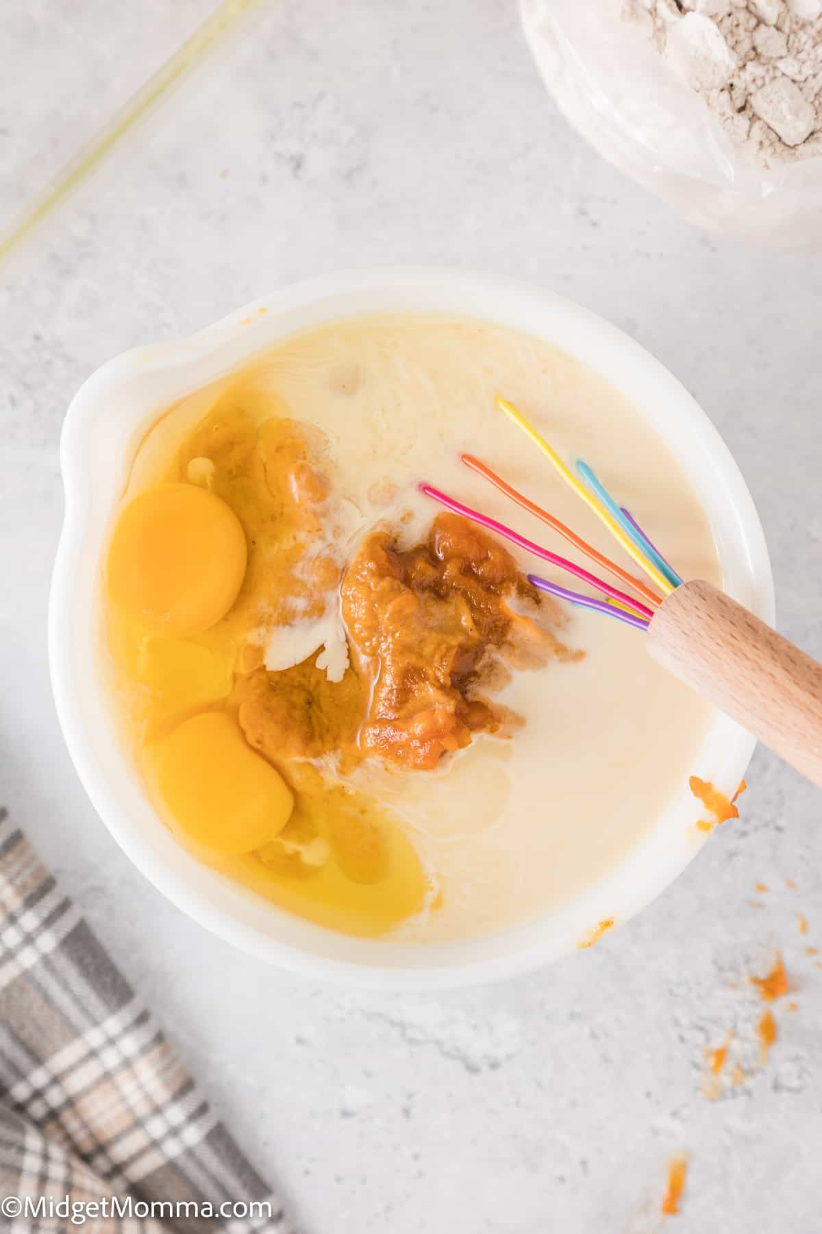canned pumpkin pie filling, eggs, and evaporated milk in a mixing bowl