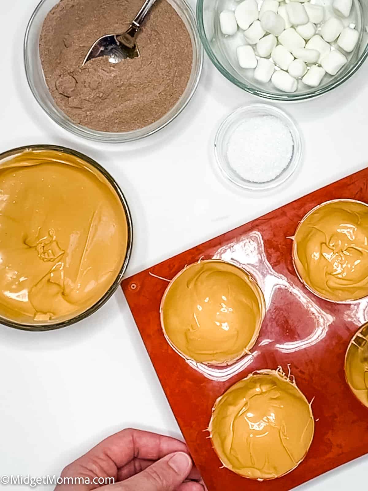 melted caramel candy melts being spooned into sphere molds