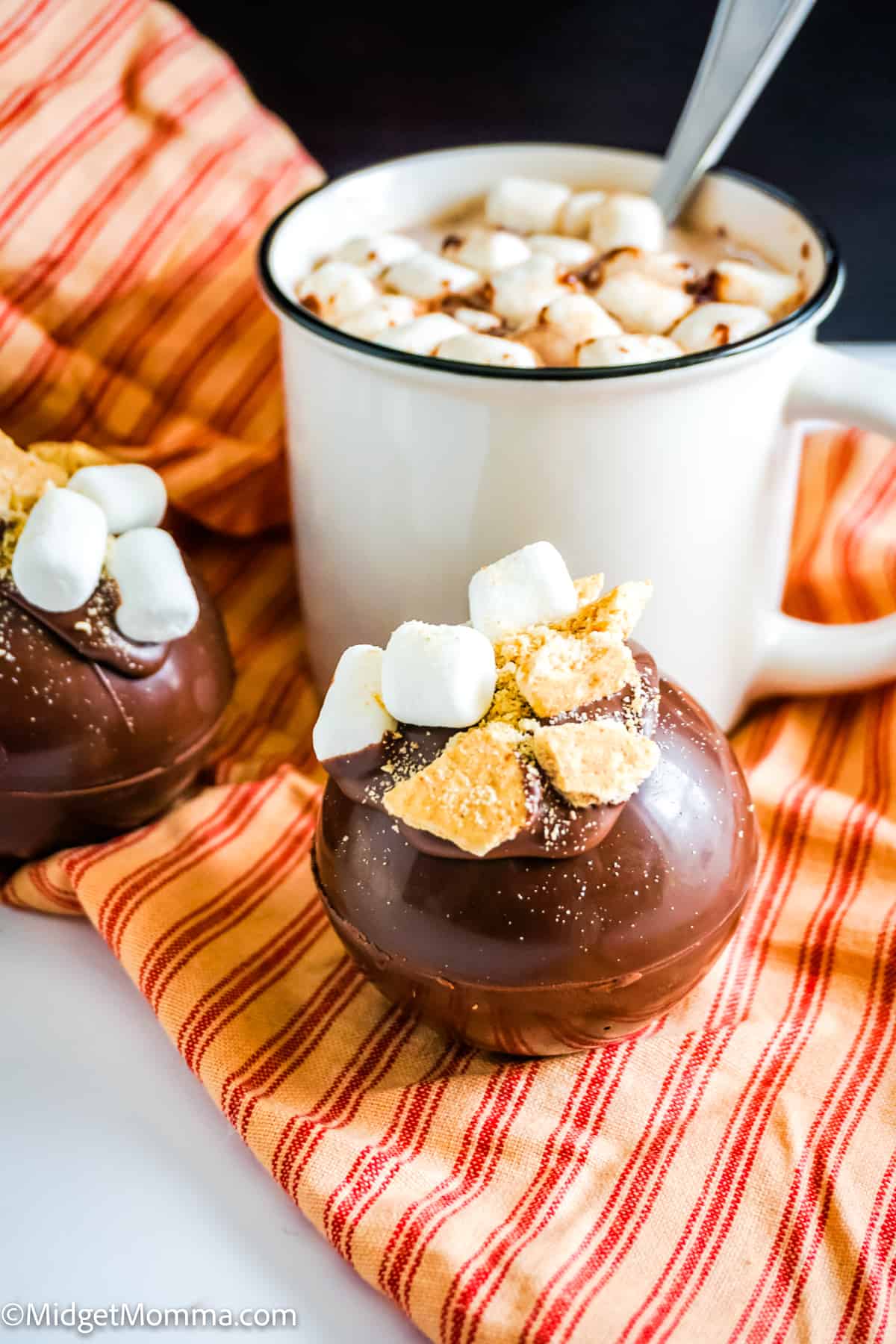 2 smores hot chocolate bombs and a cup of hot chocolate