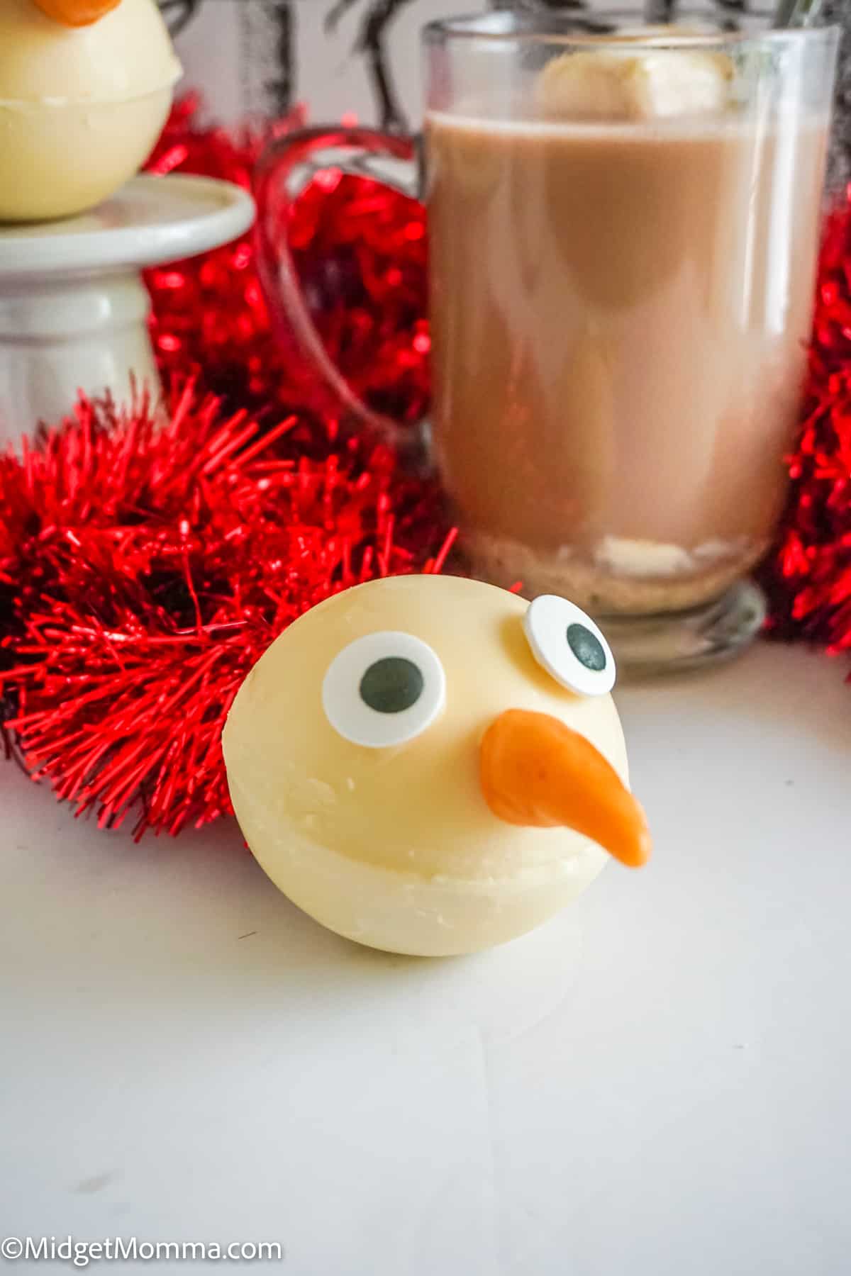 Snowman Hot Chocolate Bombs with a cup of hot chocolate