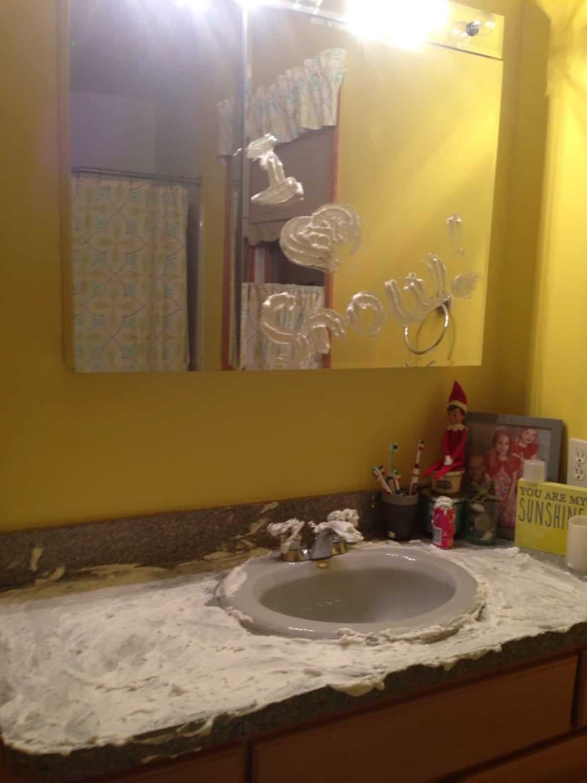 A yellow bathroom with a sink and mirror.