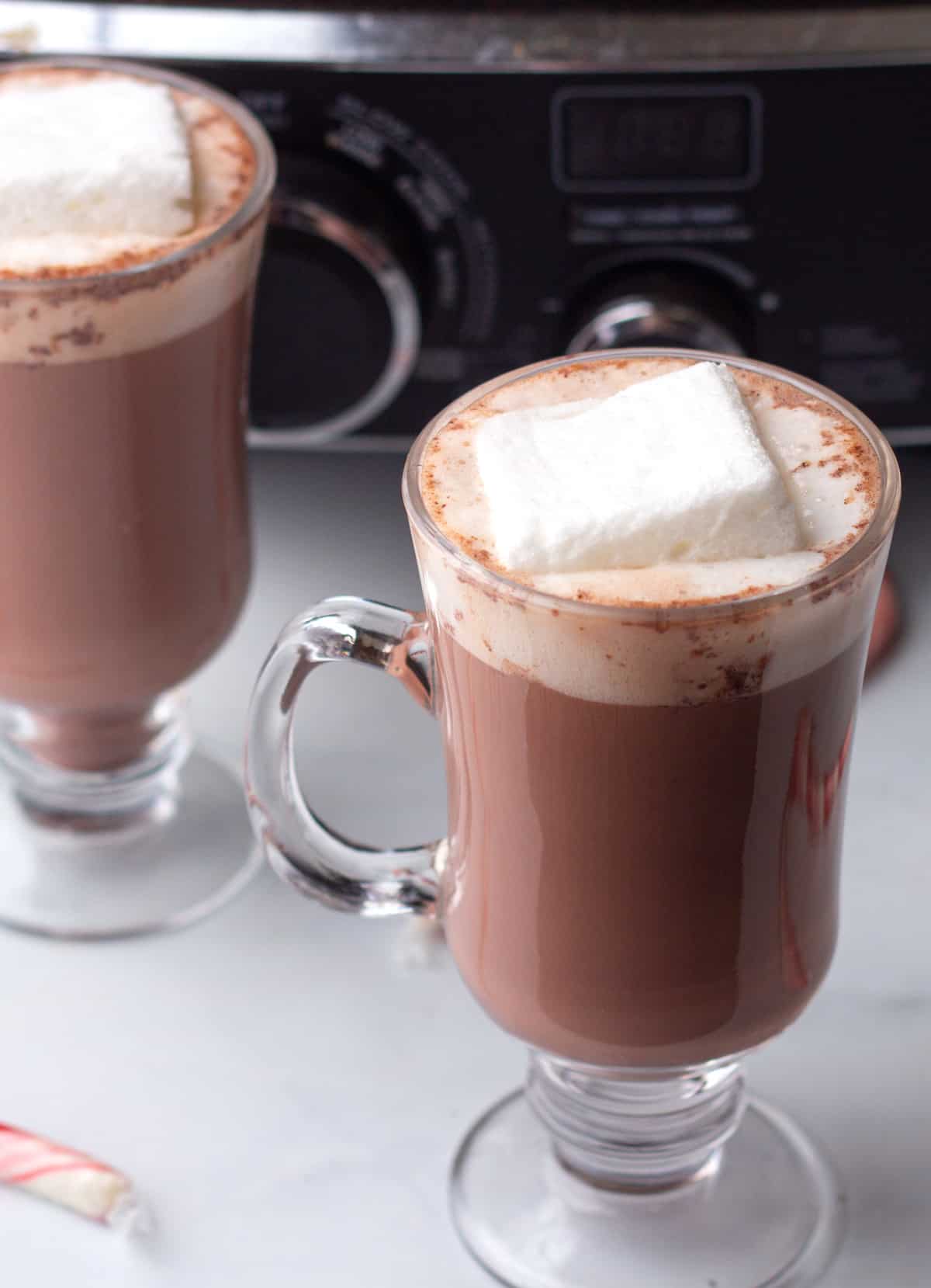 Two glasses of hot chocolate with marshmallows on top.