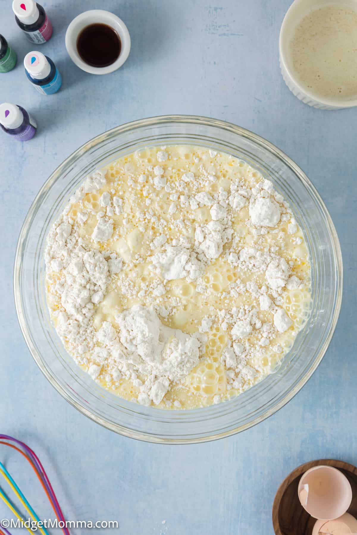 A bowl filled with batter - flour, eggs and sugar and other ingredients for rainbow pancakes. 