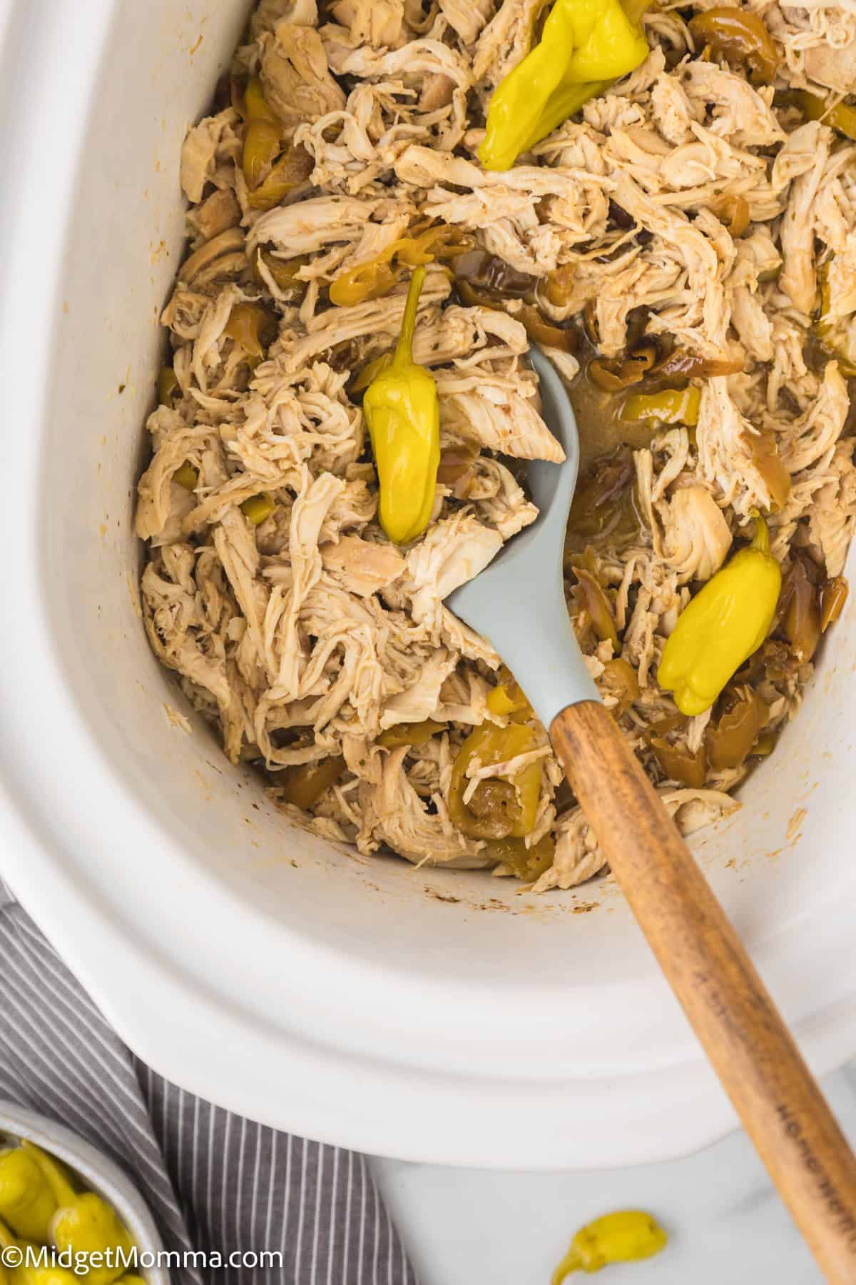 cooked shredded chicken being mixed vin withe sauce made in the slow cooker
