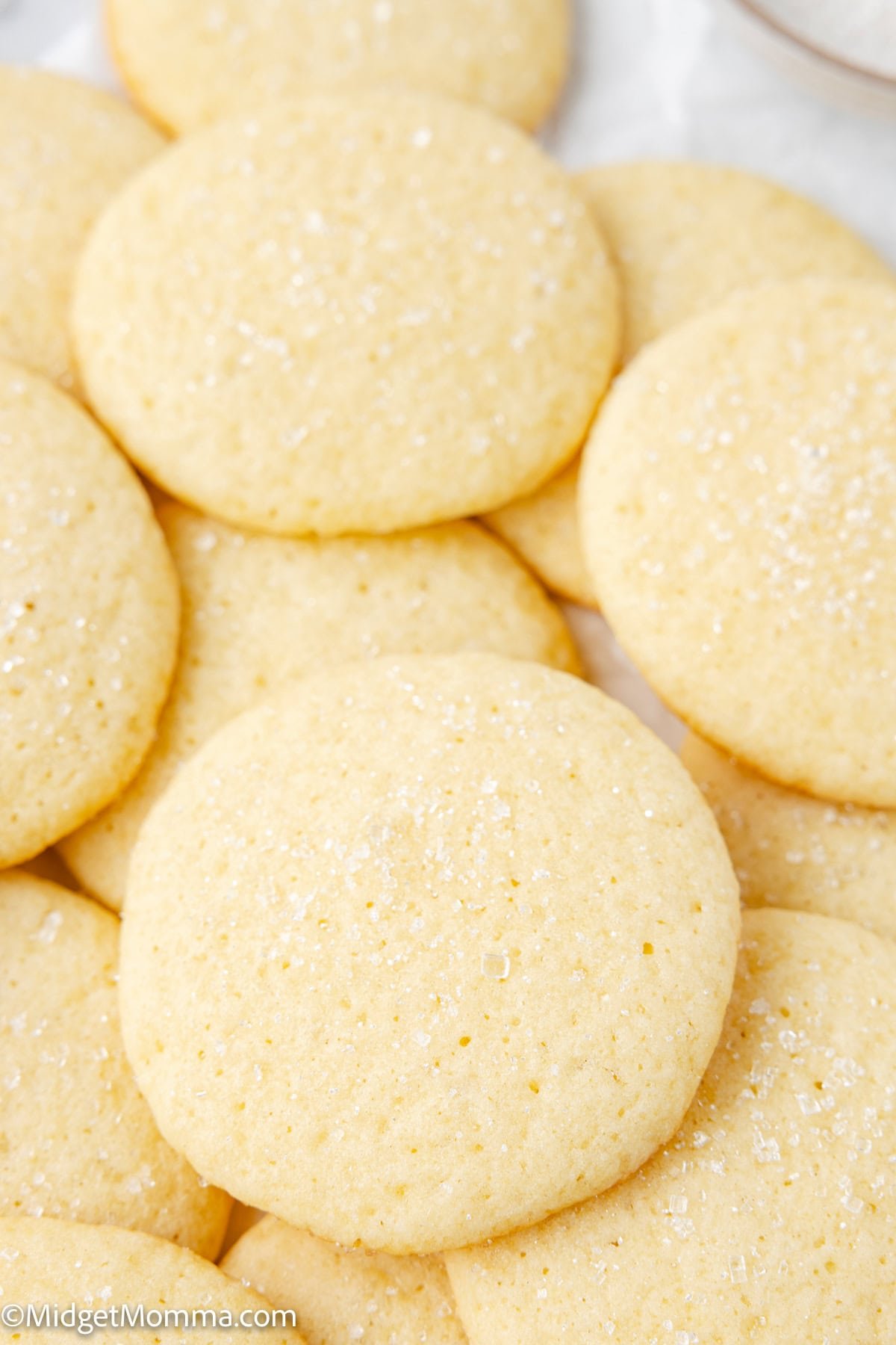 A close-up of several round, lightly golden Original Girl Scout Cookies sugar cookies with a sprinkling of sugar on top.